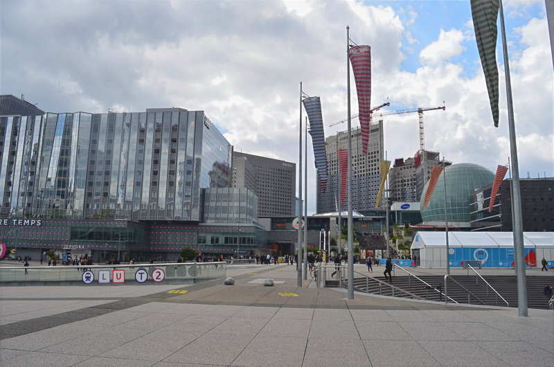 13 - La Défense business district in Paris, France, featuring the Les Quatre Temps shopping center and the esplanade under a cloudy sky